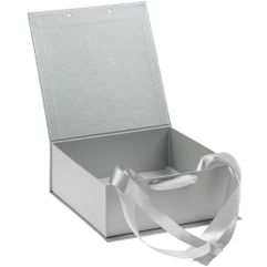 Коробка выполнена из переплетного картона, кашированного дизайнерской бумагой Majestic, с крышкой на лентах.